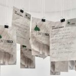 Ausgefüllte Mitmachkarten der Ausstellung mit der Aufforderung "Mein schönster Unterrock-Moment". Sie hängen unter einem Rock und sind Teil der Ausstellung Unterrock - Unerhört, Unerkannt.